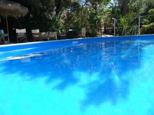 a large blue swimming pool with chairs in the background at Agriturismo Ridocco in Corleone