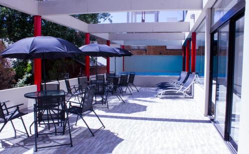 a group of chairs and tables with umbrellas on a patio at San Remo Viking Hotel in Pinamar