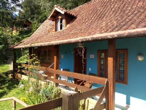 a small blue house with a brown roof at Chalés de Analuz in Visconde De Maua