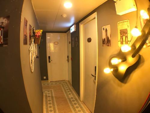 a hallway with a door and lights on the wall at Soso Hostel in Hong Kong