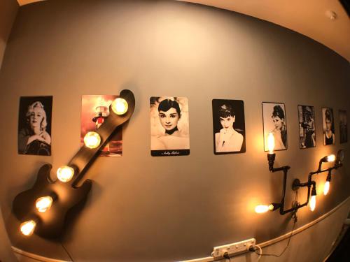 a room with a guitar on a wall with pictures at Soso Hostel in Hong Kong