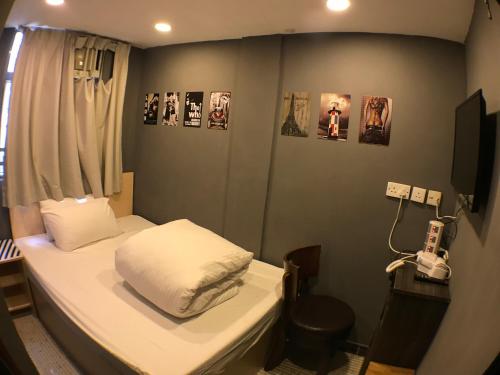 a small room with a bed and a phone at Soso Hostel in Hong Kong