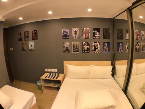 a bedroom with two beds and pictures on the wall at Soso Hostel in Hong Kong