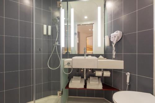 La salle de bains est pourvue d'un lavabo et d'un miroir. dans l'établissement ibis Kolkata Rajarhat - An Accor Brand, à Kolkata