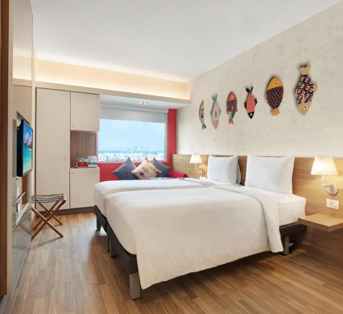 um quarto de hotel com uma cama grande e uma televisão em ibis Kolkata Rajarhat - An Accor Brand em Calcutá