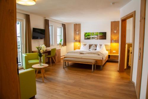 Hotel Irmgard في Strass im Attergau: غرفة نوم بسرير وطاولة وكراسي