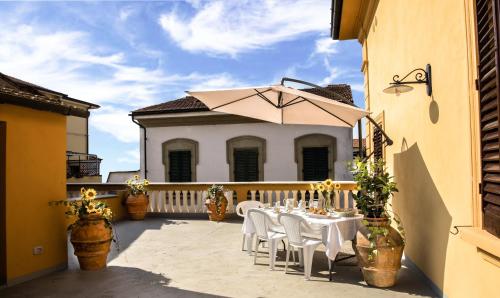 a patio with a table and an umbrella at Villa Antiche Mura in Empoli