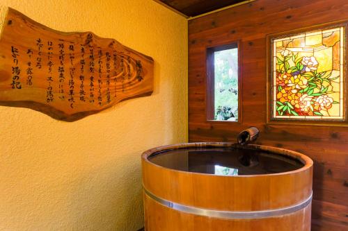 a wooden tub in a room with a window at HAKONE GORA ONSEN Hotel Kasansui in Hakone