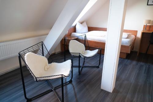a room with three chairs and a bed at Hotel Rheinpromenade8 in Emmerich