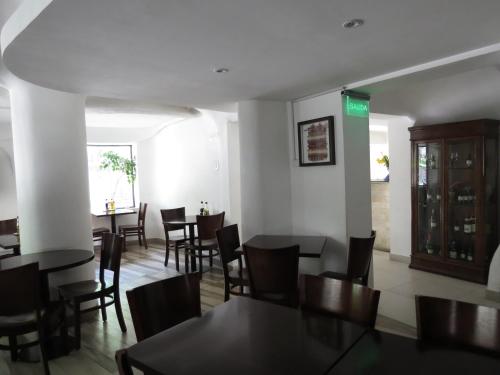 a dining room with black tables and chairs at Hotel Montecarlo Santiago in Santiago