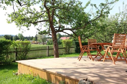 un patio con 2 sillas y una mesa bajo un árbol en Ferienhaus Apfelstädt, en Tambach-Dietharz