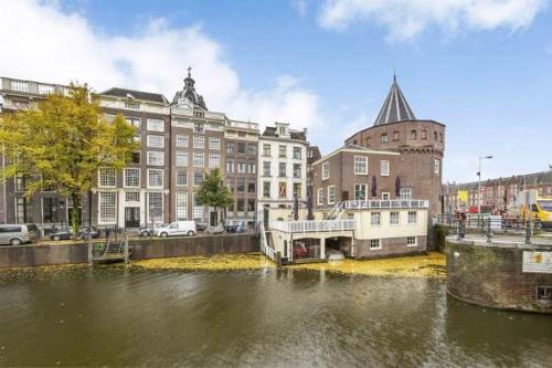 a boat in a river in a city with buildings at Redlightdistrict chinacitycentre partypalace in Amsterdam