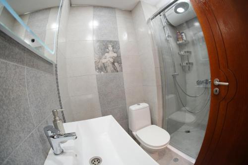 a bathroom with a toilet and a sink and a shower at Апартамент "Forest view" в комплекс "Вели Хилс" in Velingrad