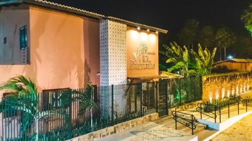a fence with benches in front of a house at night at Pousada Vila Parnaíba in Parnaíba