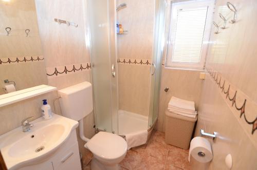 a bathroom with a toilet and a shower and a sink at Maritimo Apartments in Kotor