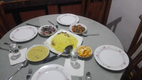 a table with plates and bowls of food on it at Mango Roots in Gampaha
