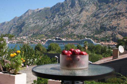 a bowl of tomatoes sitting on a table with a mountain at Maritimo Apartments in Kotor