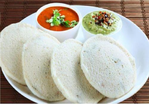 a white plate of food with soup and bread at Rks Homestay in Hampi