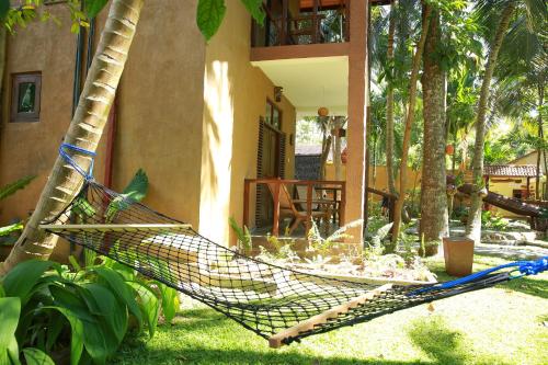 a hammock in a yard next to a house at Limecabanas-srilanka in Galle