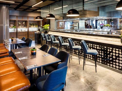 a restaurant with tables and chairs and a bar at Novotel Brisbane South Bank in Brisbane