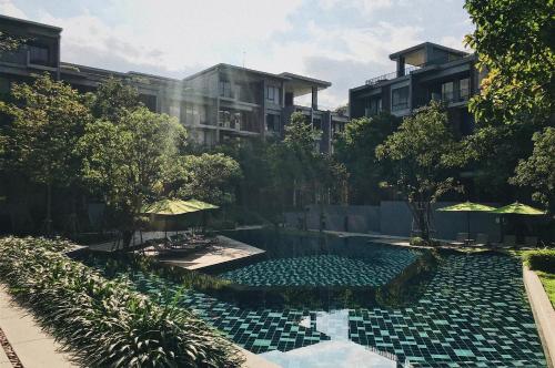 a swimming pool in front of a building at The Valley Khaoyai Tropical Style in Ban Huai Sok Noi