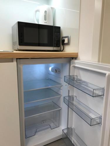 un forno a microonde posizionato sopra un frigorifero di Vila Burbonka a Nova Gorica