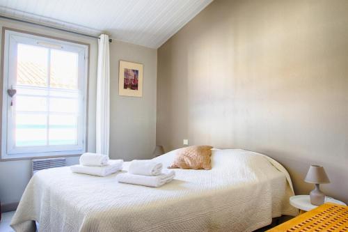 sypialnia z łóżkiem z ręcznikami w obiekcie Clos Vauban w mieście Saint-Martin-de-Ré