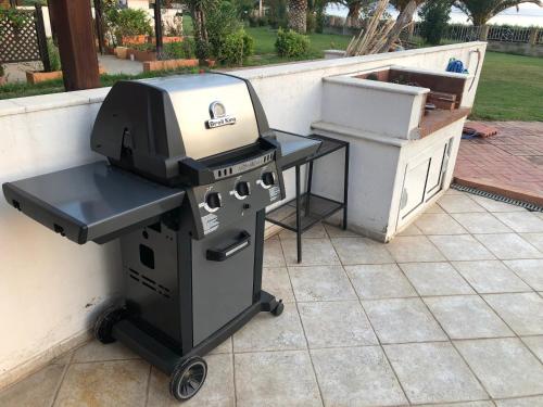 a grill sitting on a patio next to a table at DISTRiCT 01 -Luxurious Villa with private beach in Metókhion Konstamonítou