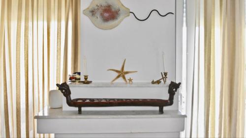 a white fireplace with a bench in a room at DISTRiCT 01 -Luxurious Villa with private beach in Metókhion Konstamonítou