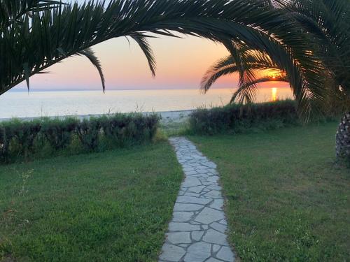 a path leading to the beach at sunset at DISTRiCT 01 -Luxurious Villa with private beach in Metókhion Konstamonítou
