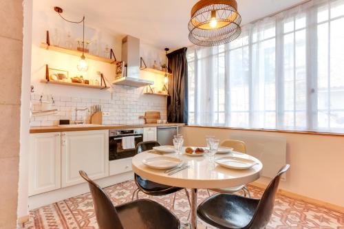 une cuisine avec une table et des chaises dans une pièce dans l'établissement Le Saint-Louis, à Montpellier