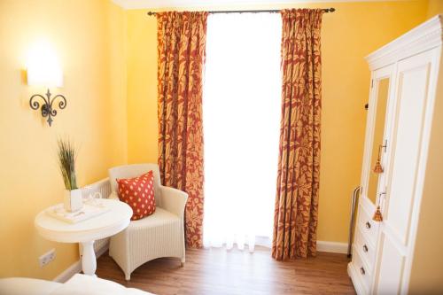a room with a table and a chair and a window at HIRSCH 1783 Hotel LANDHAUS in Langenargen