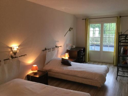 ein Hotelzimmer mit 2 Betten und einem Fenster in der Unterkunft The Originals City, Hôtel Le Cheval Rouge, Tours Ouest (Inter-Hotel) in Villandry