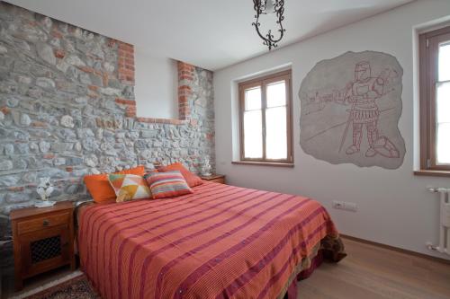 een slaapkamer met een bed en een bakstenen muur bij Il Rifugio del Monaco in Cividale del Friuli