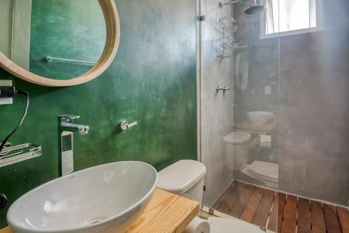 a bathroom with a sink and a toilet and a mirror at Selina Casco Viejo Panama City in Panama City