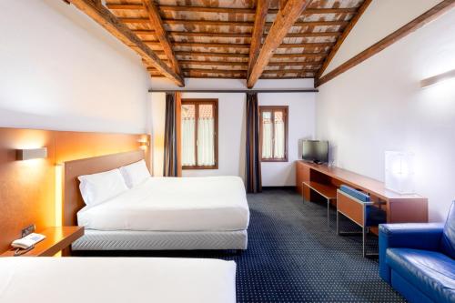 une chambre d'hôtel avec un lit et un canapé dans l'établissement Eurostars Residenza Cannaregio, à Venise