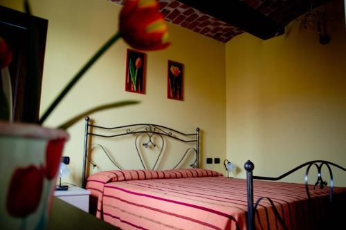 a bedroom with a bed with a pink blanket at Agriturismo Monbertola in Govone