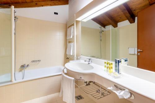 a bathroom with a sink and a tub and a mirror at Eurostars Residenza Cannaregio in Venice