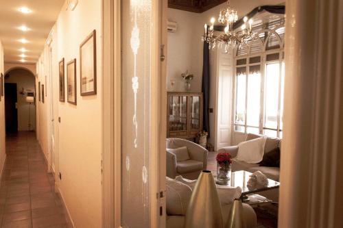 sala de estar con sofá y lámpara de araña en Antica Dimora Caruso, en Catania