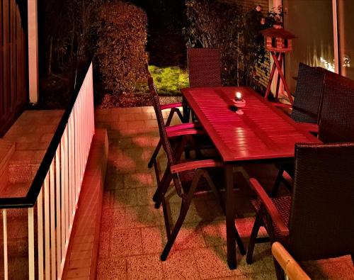 a red wooden table and chairs on a patio at Ferienhaus "Auberge Jolie" in Aachen