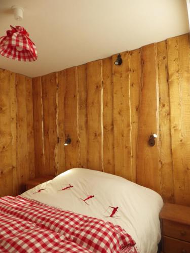 a bedroom with a bed with a red and white blanket at Gîte du Lac in Gérardmer