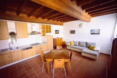 a kitchen and living room with a table and a couch at Villa La Lolliana in Monestirolo