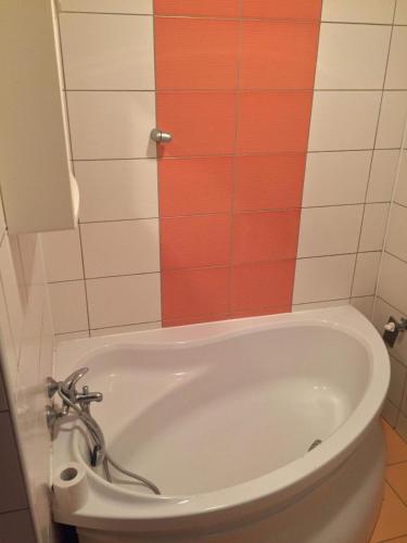 a bath tub in a bathroom with colorful tiles at Hostel Fontana in Žilina