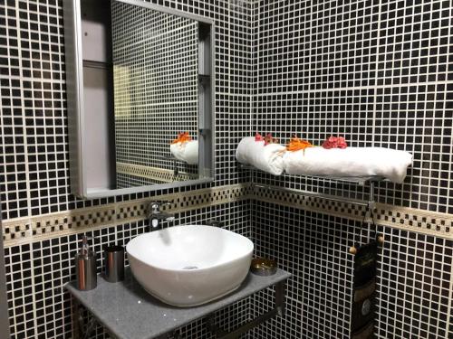 a bathroom with a white sink and a mirror at Mer Riviere Self Catering Apartment in Beau Vallon