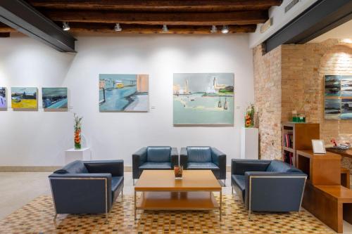 a room with chairs and a table and paintings at Eurostars Residenza Cannaregio in Venice