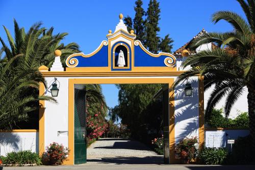a gate to a house with a bell on top at Herdade da Calada in Azaruja