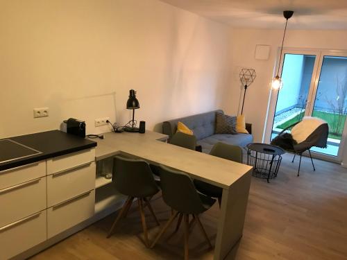 eine Küche und ein Wohnzimmer mit einem Tisch und Stühlen in der Unterkunft Luxus Apartment Lake&City in Friedrichshafen