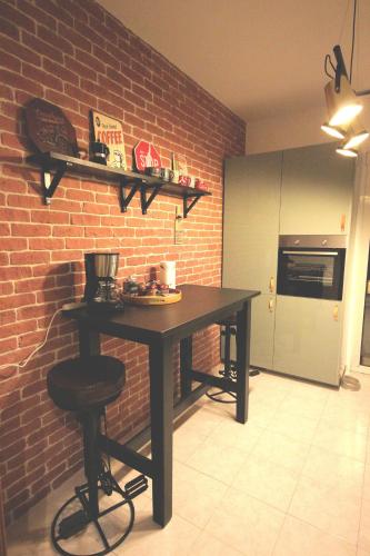 a kitchen with a table and a brick wall at La Serenissima - 15 min to Venice City Center - Free Parking in Campalto