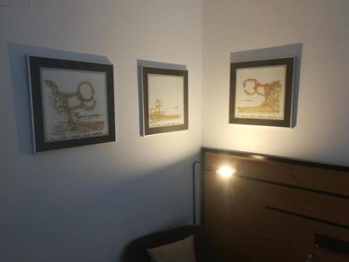a room with three framed pictures on the wall at Pensión La Perla in Donostia-San Sebastián