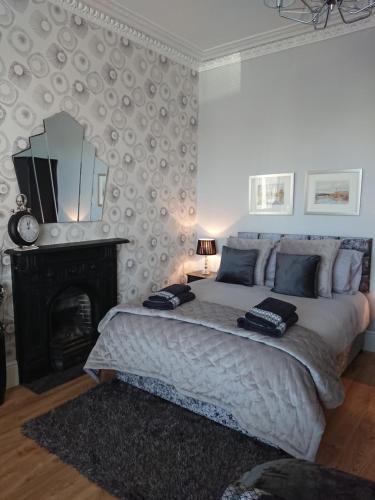 a bedroom with a bed with a fireplace and a mirror at William Wallace Apartment in Stirling